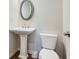 Half bathroom featuring a pedestal sink, an oval mirror and a toilet at 115 Laurelwood Ln, Dallas, GA 30157
