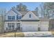 Beautiful two-story home with a three car garage, stone accents, and a charming front porch with rocking chairs at 115 Laurelwood Ln, Dallas, GA 30157