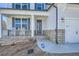 Close up of a lovely front porch with stone accents, white rocking chairs, and a storm door, with new landscaping at 115 Laurelwood Ln, Dallas, GA 30157