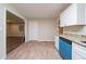 An airy kitchen looks into the living room with vinyl floors and white cabinets at 3645 Larkspur Ter, Decatur, GA 30032