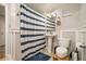 Clean bathroom with a pedestal sink, toilet, blue and white striped shower curtain, and modern fixtures at 3501 Roswell Ne Rd # 211, Atlanta, GA 30305
