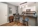 Kitchen area with counter seating, featuring modern appliances, stone countertops, and wood flooring at 3501 Roswell Ne Rd # 211, Atlanta, GA 30305