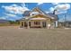 A beautiful white home featuring a covered porch with brick and wood detailing in an expansive grassy backyard at 195 Hope Hollow Rd, Loganville, GA 30052