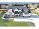Aerial view of a gorgeous two-story modern farmhouse with well-kept landscaping and a long driveway at 195 Hope Hollow Rd, Loganville, GA 30052