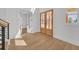 Sunlit foyer with hardwood floors, a staircase with iron railings, and a view of the front yard at 195 Hope Hollow Rd, Loganville, GA 30052