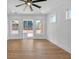 Bright living room with wood floors, a modern ceiling fan, and sliding glass doors to the outside at 195 Hope Hollow Rd, Loganville, GA 30052