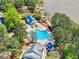Aerial view of a pool area with mature trees, a lakefront pier, and lush landscaping surrounding the community amenity at 535 Woodbrook Way, Lawrenceville, GA 30043
