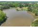 This aerial view shows a lake with a dock, gazebo, and surrounding lush greenery at 535 Woodbrook Way, Lawrenceville, GA 30043