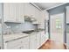Modern kitchen with marble countertops, white cabinets, and stainless steel appliances at 535 Woodbrook Way, Lawrenceville, GA 30043
