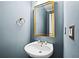Stylish powder room featuring a pedestal sink, gold mirror, and blue walls at 535 Woodbrook Way, Lawrenceville, GA 30043