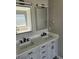 Bathroom featuring a gray double vanity with marble countertop, dual mirrors, and modern fixtures at 4080 Brushymill Ct, Loganville, GA 30052