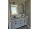 Bathroom featuring a gray double vanity with marble countertop, dual mirrors, and modern fixtures at 4080 Brushymill Ct, Loganville, GA 30052