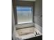 A luxurious bathtub with hydro jets situated beneath a frosted window allowing for natural light at 4080 Brushymill Ct, Loganville, GA 30052