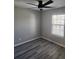 Cozy bedroom showcasing a ceiling fan and a window allowing natural light to brighten the luxury vinyl plank flooring at 4080 Brushymill Ct, Loganville, GA 30052
