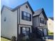 Two-story home featuring tan siding, black shutters, and a driveway leading to a single-car garage at 4080 Brushymill Ct, Loganville, GA 30052