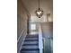 A well-lit staircase with modern wood-look flooring ascends to the upper level of the home at 4080 Brushymill Ct, Loganville, GA 30052