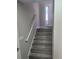 Ascending staircase with light gray wood floors leading to a bright entryway with natural light at 4080 Brushymill Ct, Loganville, GA 30052