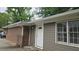 Home exterior featuring brick and siding with white trim, windows, and a door, offering a glimpse of the backyard at 679 Winchester Ln, Norcross, GA 30071