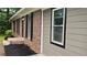 The brick and siding home with dark shutters provides a glimpse of its landscaping at 679 Winchester Ln, Norcross, GA 30071