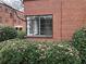 Building exterior with a large, modern window surrounded by symmetrical greenery and a matching brick facade at 1148 Briarcliff Ne Rd # 1, Atlanta, GA 30306