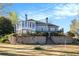 View of the home with a stone retaining wall, stairway, and beautiful green landscape at 2220 Emerald Dr, Jonesboro, GA 30236