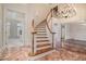 Grand foyer features a curved staircase, marble flooring, and elegant chandelier, creating a luxurious ambiance at 2220 Emerald Dr, Jonesboro, GA 30236