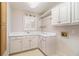 Convenient laundry room with white cabinets, sink, and ample counter space at 2220 Emerald Dr, Jonesboro, GA 30236