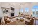 Elegant living room featuring hardwood floors, a fireplace, and expansive windows with beautiful lake views at 2220 Emerald Dr, Jonesboro, GA 30236