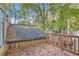 View of wood deck overlooking wooded area, complete with wooden railings and autumn leaves at 3111 Fairington Dr, Lithonia, GA 30038