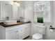 Bathroom featuring double sink vanity, white cabinets, a window, and toilet at 360 Peyton Sw Rd, Atlanta, GA 30311