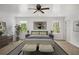 Bright bedroom featuring neutral walls, ceiling fan, two windows, and light colored bed and ottomans at 360 Peyton Sw Rd, Atlanta, GA 30311