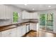Bright kitchen with butcher block countertops, white cabinets and stainless steel appliances plus a sliding door to the deck at 360 Peyton Sw Rd, Atlanta, GA 30311