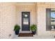 Close-up of the welcoming front door, with dark shutters, decorative wreath, and potted plants at 130 Brayden Park Dr, Canton, GA 30115