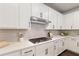 This kitchen features stainless steel appliances, light-colored cabinets, and tiled backsplash at 130 Brayden Park Dr, Canton, GA 30115