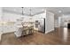 Bright kitchen features stainless appliances, white cabinets, island with seating and modern pendant lighting at 130 Brayden Park Dr, Canton, GA 30115