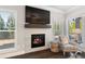 Cozy living room features a fireplace with mantle and TV, with natural light from the windows at 130 Brayden Park Dr, Canton, GA 30115