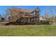 Back of house featuring a brick exterior, multiple decks, a well-manicured lawn, and retaining walls at 160 Glenmore Ln, Mcdonough, GA 30253