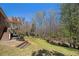 Spacious backyard with mature trees, a creek, and a stone-paved patio leading to a tiered deck at 160 Glenmore Ln, Mcdonough, GA 30253