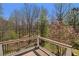 Wooden deck overlooking a lush, wooded backyard with flowering trees and a serene creek at 160 Glenmore Ln, Mcdonough, GA 30253