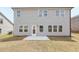 Backyard featuring a patio and spacious lawn with an adjacent home in view at 6910 Winchester Pl, Fairburn, GA 30213