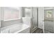 Clean bathroom with a tub, shower, and frosted window for privacy at 6910 Winchester Pl, Fairburn, GA 30213
