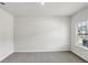 Bright, carpeted bedroom with a window offering neighborhood views at 6910 Winchester Pl, Fairburn, GA 30213