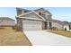 Attractive two-story home featuring stone accents, gray siding and a two-car garage at 6910 Winchester Pl, Fairburn, GA 30213