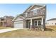 Lovely two-story home boasts stone accents, gray siding and a two-car garage at 6910 Winchester Pl, Fairburn, GA 30213