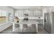 Staged kitchen featuring an island, stainless steel appliances and gray cabinets at 6910 Winchester Pl, Fairburn, GA 30213
