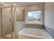 Stylish bathroom showcases tub with tile surround, shower, and window for natural light at 254 Arnewood Cir, Mcdonough, GA 30253