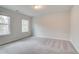Bright bedroom features plush carpeting, neutral paint, and two windows providing natural light at 254 Arnewood Cir, Mcdonough, GA 30253