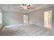 Large main bedroom with neutral paint, plush carpeting, tray ceiling, and doorway to bathroom at 254 Arnewood Cir, Mcdonough, GA 30253