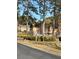 View of multi-story townhouse complex featuring mature trees and well-maintained landscaping at 2340 Beaver Ruin Rd, Norcross, GA 30071