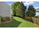 Grassy backyard with a privacy fence, lush trees, and outdoor patio with outdoor seating at 2360 Brookgreen Commons, Kennesaw, GA 30144